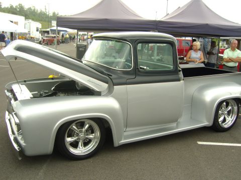 2007 Ford Mustang - A customized classic pickup truck is displayed with its hood open at a car show.