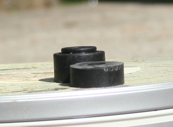 Two black rubber suspension bushings, one with '6007' stamped on its side