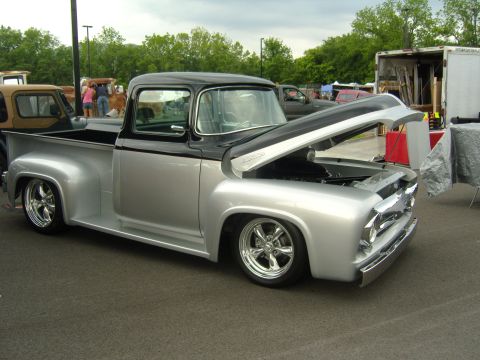 2007 Ford Mustang - A custom 1956 Ford F-100 pickup truck is displayed with its hood up at an outdoor event.