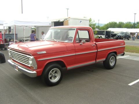 2007 Ford Mustang - A red 1967 Ford F-Series pickup truck is parked at an outdoor event.