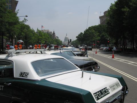 1991 Ford Crown Victoria - Several police cars are parked along a street, with the Capitol building visible in the distance.