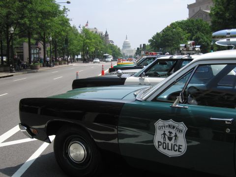1991 Ford Crown Victoria - Several police cars are parked along a street, with the US Capitol building visible in the distance.