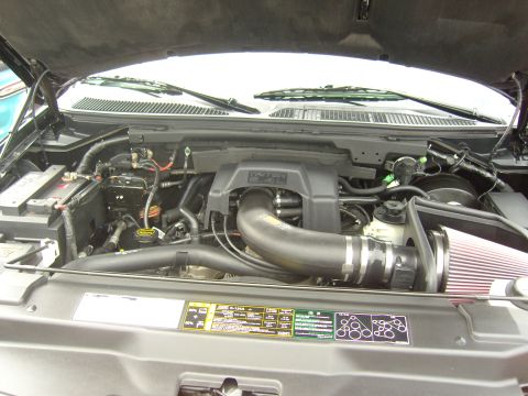 2007 Ford Mustang - The engine bay of a vehicle is shown with the hood open, revealing the engine components and various labels.