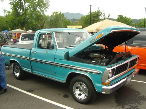 2007 Ford Mustang - A teal 1970 Ford F-100 pickup truck is displayed with its hood open, revealing the engine compartment.