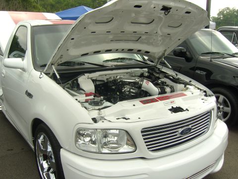 2007 Ford Mustang - White Ford SVT Lightning pickup truck with hood open, displaying its engine bay and aftermarket intake.