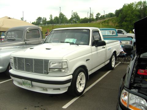 2007 Ford Mustang - A white 1995 Ford F-150 Lightning pickup truck is parked at an outdoor event.