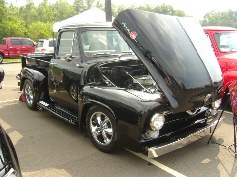 2007 Ford Mustang - A classic black Ford pickup truck is displayed with its hood open, revealing the engine bay.