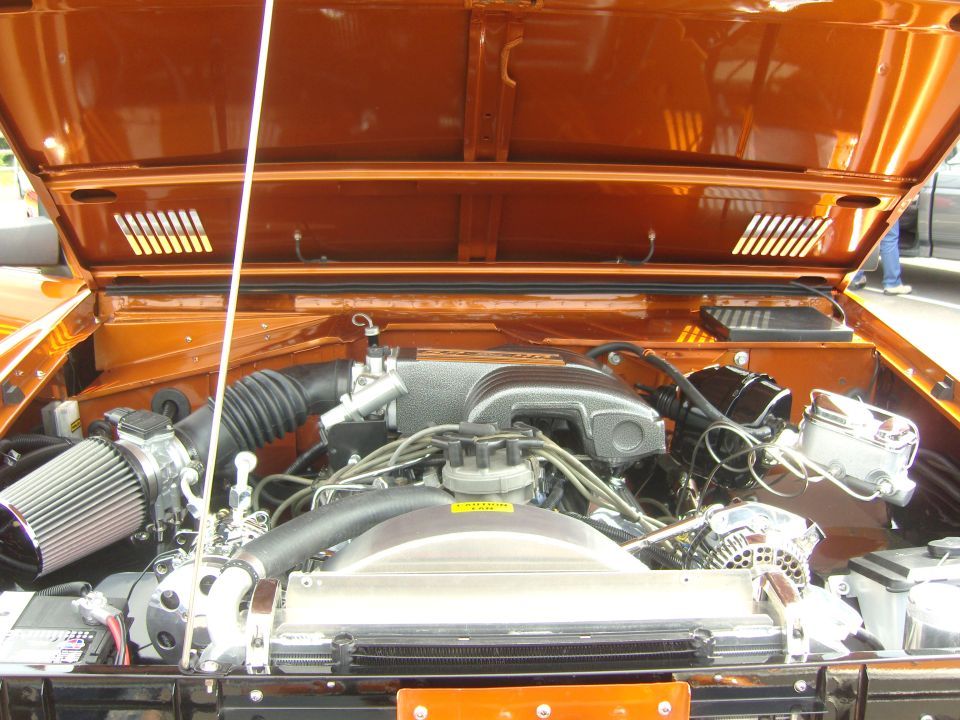 Orange Bronco engine bay with chrome accents and aftermarket air intake