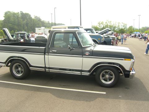 2007 Ford Mustang - A classic two-tone pickup truck is parked at an outdoor event with other vehicles and attendees.