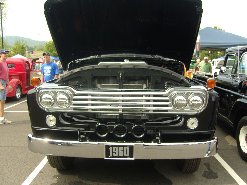 Black 1960 Ford F-Series truck front view with hood open, chrome grille, and "1960" license plate