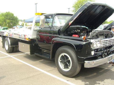 2007 Ford Mustang - This black Ford F-series tow truck, likely from 1957, is displayed with its hood open, revealing the engine compartment.
