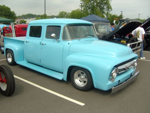 2007 Ford Mustang - A custom-built, light blue crew cab pickup truck is parked at an outdoor event, with other vehicles visible in the background.