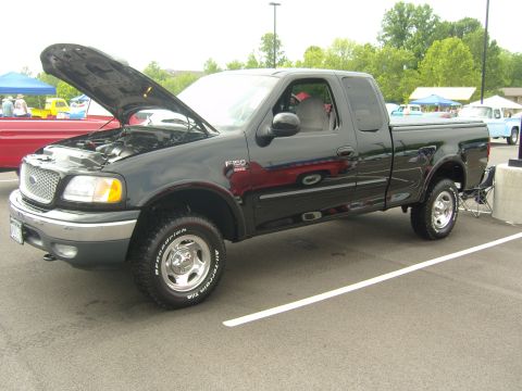 2007 Ford Mustang - Black Ford F-150 pickup truck with hood open, parked at an outdoor event.