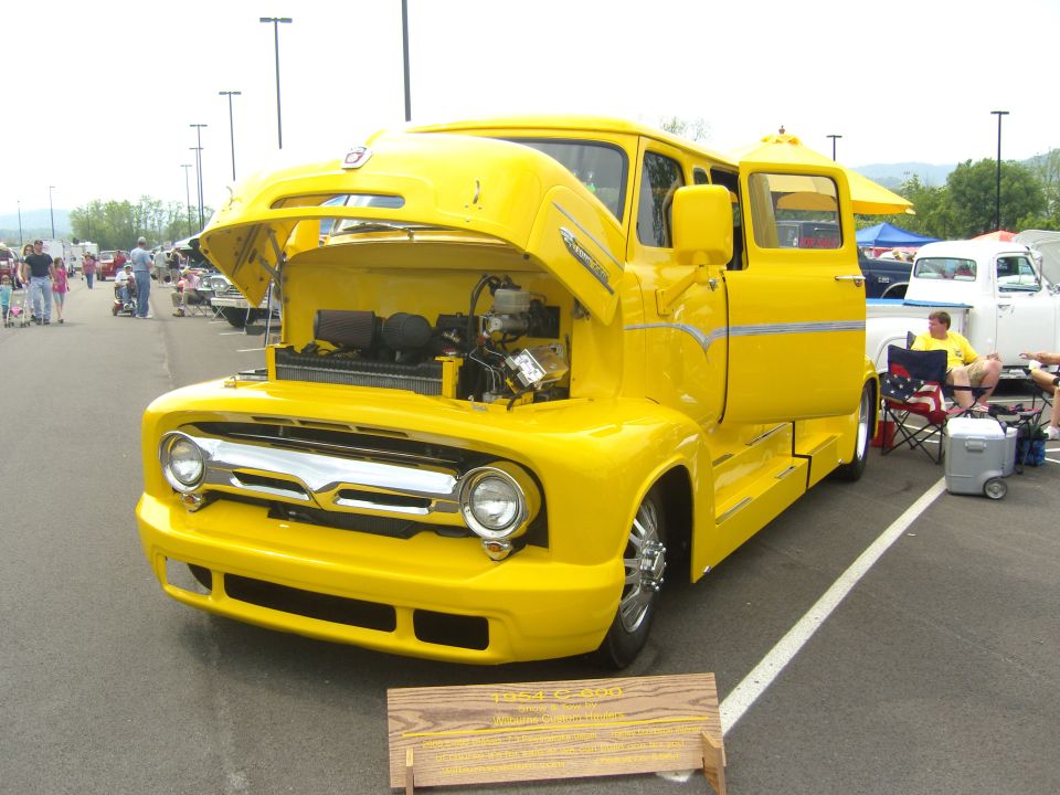 Yellow custom truck with hood open, showing engine. Sign in front says 1954 C-500
