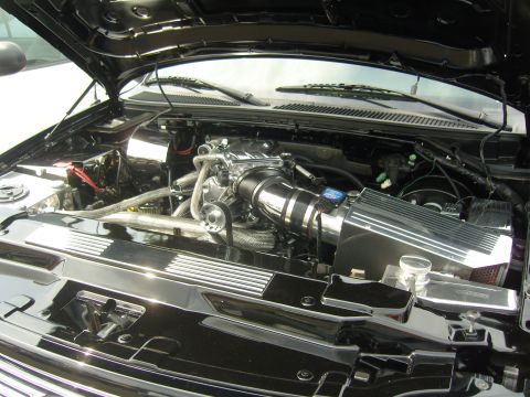 2007 Ford Mustang - The engine bay features a polished intake system and chrome accents, with the hood open.