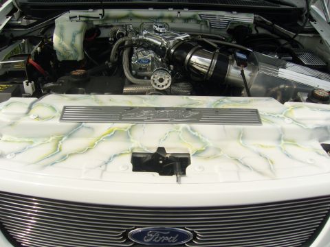 2007 Ford Mustang - The engine bay of a white truck features a custom paint job with a marble effect on the engine cover and air intake system.