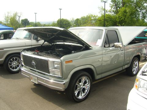 2007 Ford Mustang - A silver pickup truck is parked with its hood and bed cover open, displaying its engine and interior.