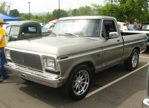 2007 Ford Mustang - A silver pickup truck with custom wheels is parked at an outdoor event.