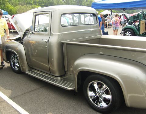 2007 Ford Mustang - A classic silver pickup truck is displayed at an outdoor event with other vehicles in the background.