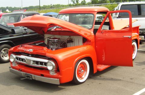2007 Ford Mustang - This orange 1956 Ford F-100 pickup truck is displayed with its hood and door open, revealing the engine.