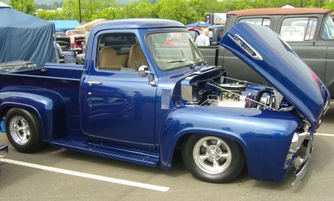 2007 Ford Mustang - Customized blue Ford F-100 pickup truck with its hood open at a car show.