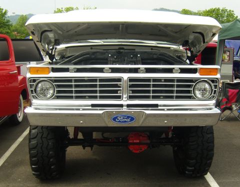 2007 Ford Mustang - A white Ford truck with its hood open is parked at an outdoor event.