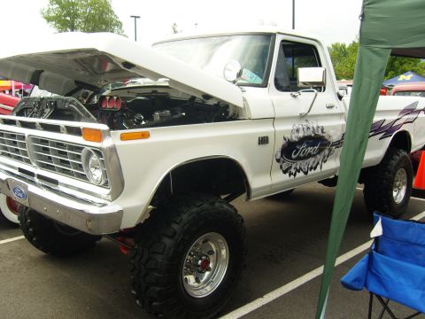 2007 Ford Mustang - This lifted Ford pickup truck, likely from the 1970s, is displayed with its hood open, revealing the engine compartment.