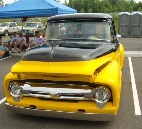 2007 Ford Mustang - A classic yellow and black Ford F-series truck is parked at an outdoor event.