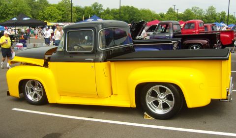 2007 Ford Mustang - A classic two-tone pickup truck is displayed at an outdoor car show, with other vehicles visible in the background.