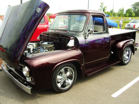 2007 Ford Mustang - A custom 1956 Ford F-100 pickup truck with a deep maroon paint job and flame graphics is displayed with its hood open.