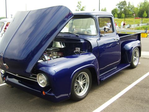 2007 Ford Mustang - A restored 1956 Ford F-100 pickup truck is displayed with its hood open, revealing the engine.