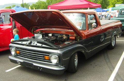 2007 Ford Mustang - A two-tone pickup truck is displayed with its hood open, revealing the engine. A "For Sale Owner" sign is visible in the windshield.