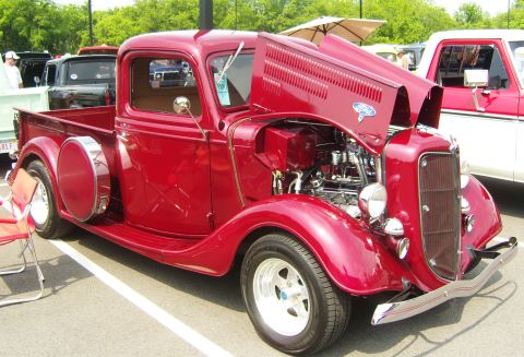 2007 Ford Mustang - A classic red Ford pickup truck is displayed with its hood open, revealing the engine compartment.