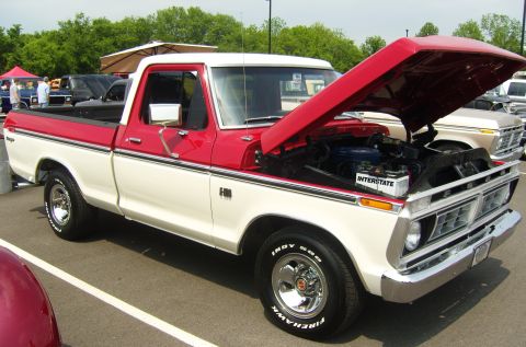 2007 Ford Mustang - This two-tone red and white Ford F-150 pickup truck is displayed with its hood open, revealing the engine compartment. The truck appears to…