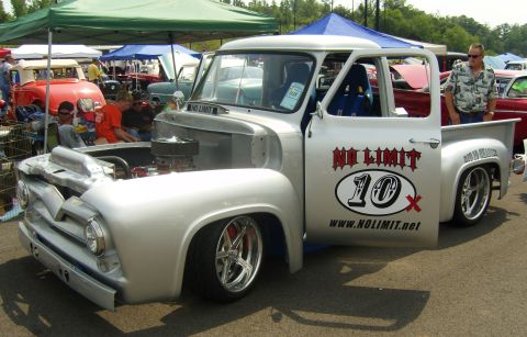 2007 Ford Mustang - A customized pickup truck is displayed at an outdoor event with other vehicles and tents in the background.