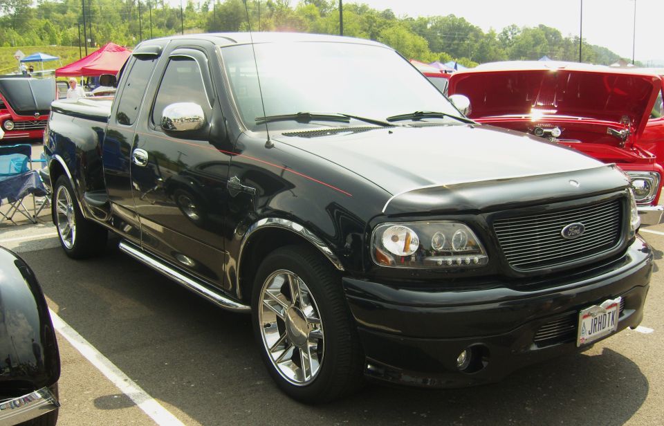 Black Ford F-150 Lightning pickup truck with chrome wheels and red pinstripes