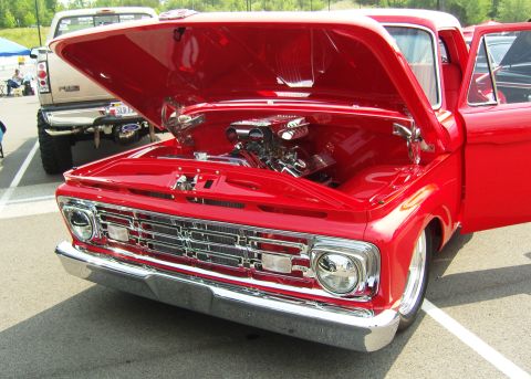2007 Ford Mustang - Front view of a red 1965 Ford F-100 pickup truck with its hood and driver's door open.