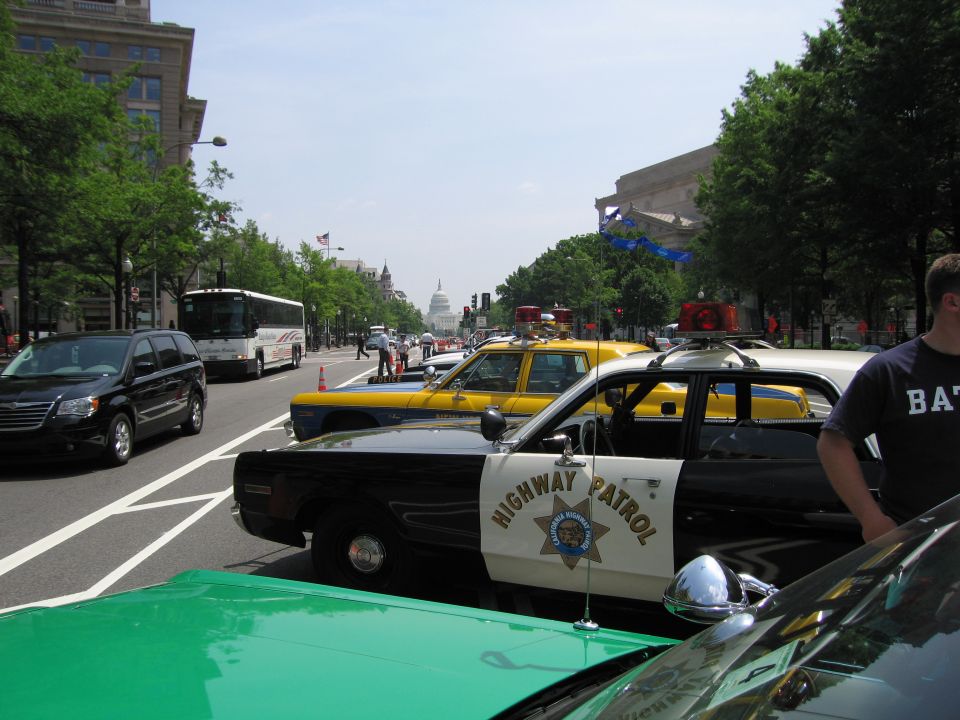Looking past a green hood over a Highway Patrol car toward the Capitol