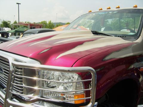 2007 Ford Mustang - A truck with a custom flame paint job is parked outdoors.