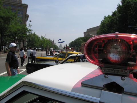 1991 Ford Crown Victoria - A 1991 Ford Crown Victoria police car is seen with its light bar in focus, part of a larger police vehicle display near the Capitol buildin…