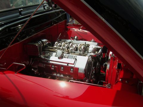 2007 Ford Mustang - Engine bay of a red car, a highly polished V8 engine with chrome details.