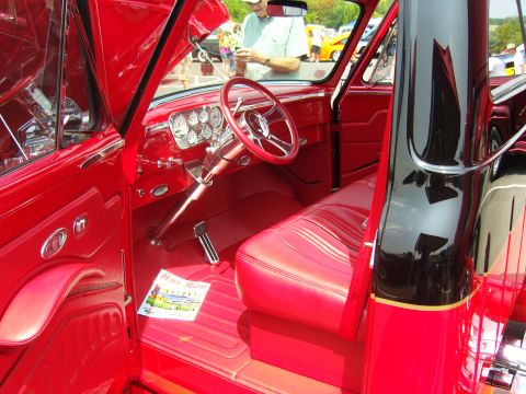 2007 Ford Mustang - The interior of a red classic truck is visible, with a magazine on the floor.