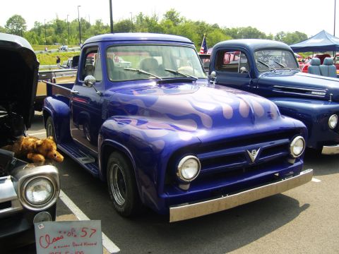 2007 Ford Mustang - Customized 1957 Ford F-100 pickup truck with flame graphics at a car show.