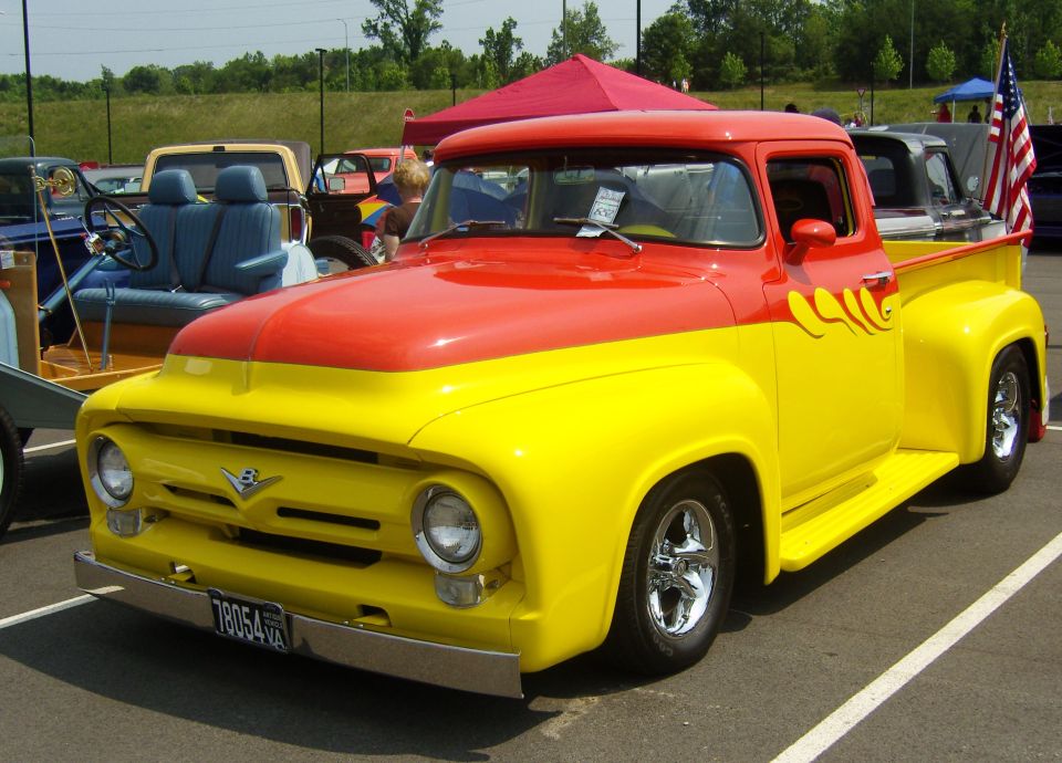 Yellow and red 1956 Ford F-series truck with flames, chrome wheels, and a VA license plate