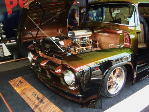 2007 Ford Mustang - A custom 1955 Ford F-100 truck is displayed with its hood open, revealing a powerful engine and unique copper detailing.
