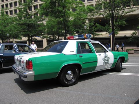 1991 Ford Crown Victoria - This 1991 Ford Crown Victoria police car features a distinctive green and white livery with 'SHERIFF' emblazoned on the door.