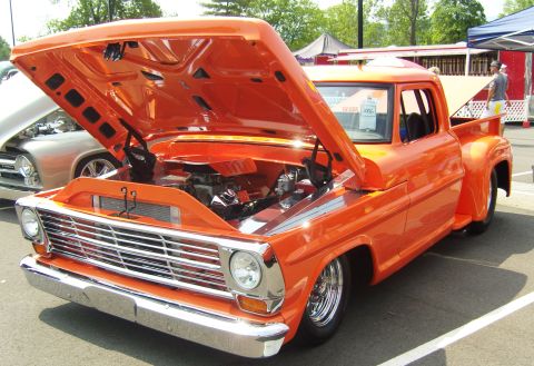 2007 Ford Mustang - This custom orange 1967 Ford F-100 pickup truck is displayed with its hood open, revealing the engine bay.
