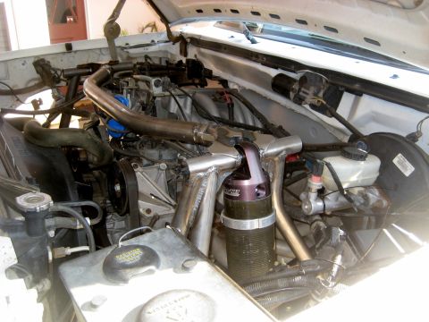 1996 Ford Bronco - Engine bay of a white vehicle, showing custom modifications and aftermarket components.