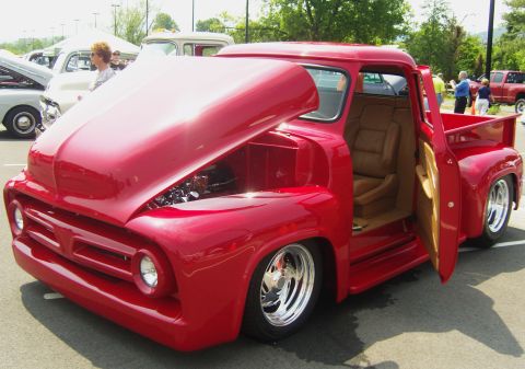 2007 Ford Mustang - Custom red 1956 Ford F-100 pickup truck on display at a car show.