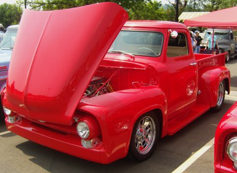 2007 Ford Mustang - A bright red classic pickup truck is displayed with its hood open, revealing the engine bay.